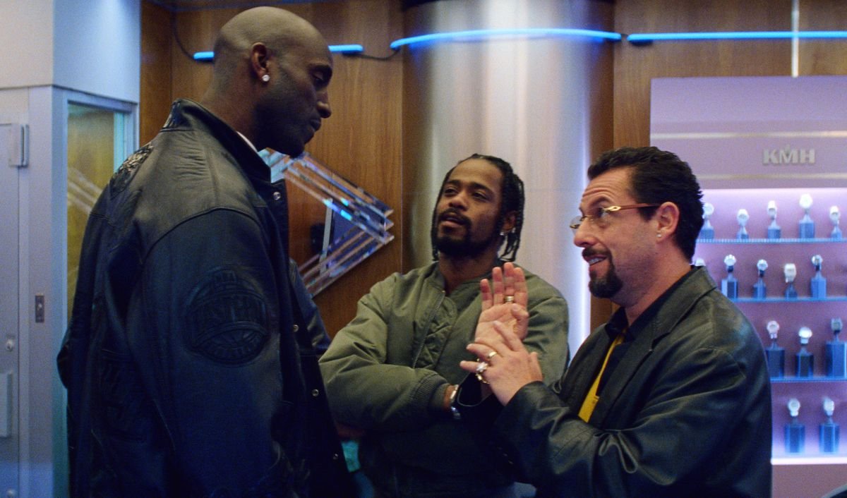 Howard (Adam Sandler) bargains with Kevin Garnett  while Demany (Lakeith Stanfield) looks on