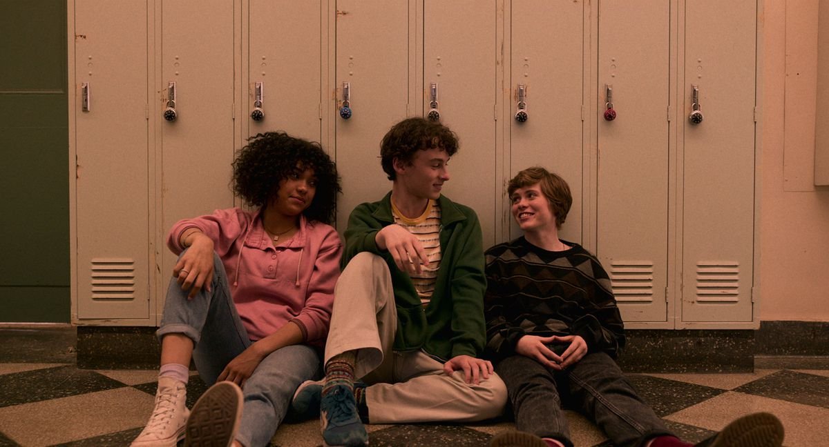 Dina, Stan, and Syd all sit on the floor of their school hallway, leaning against lockers in I Am Not Okay With This