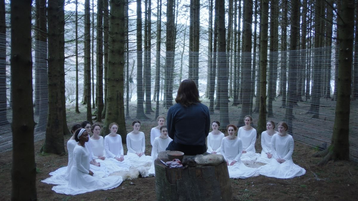 a group of women sit around a man