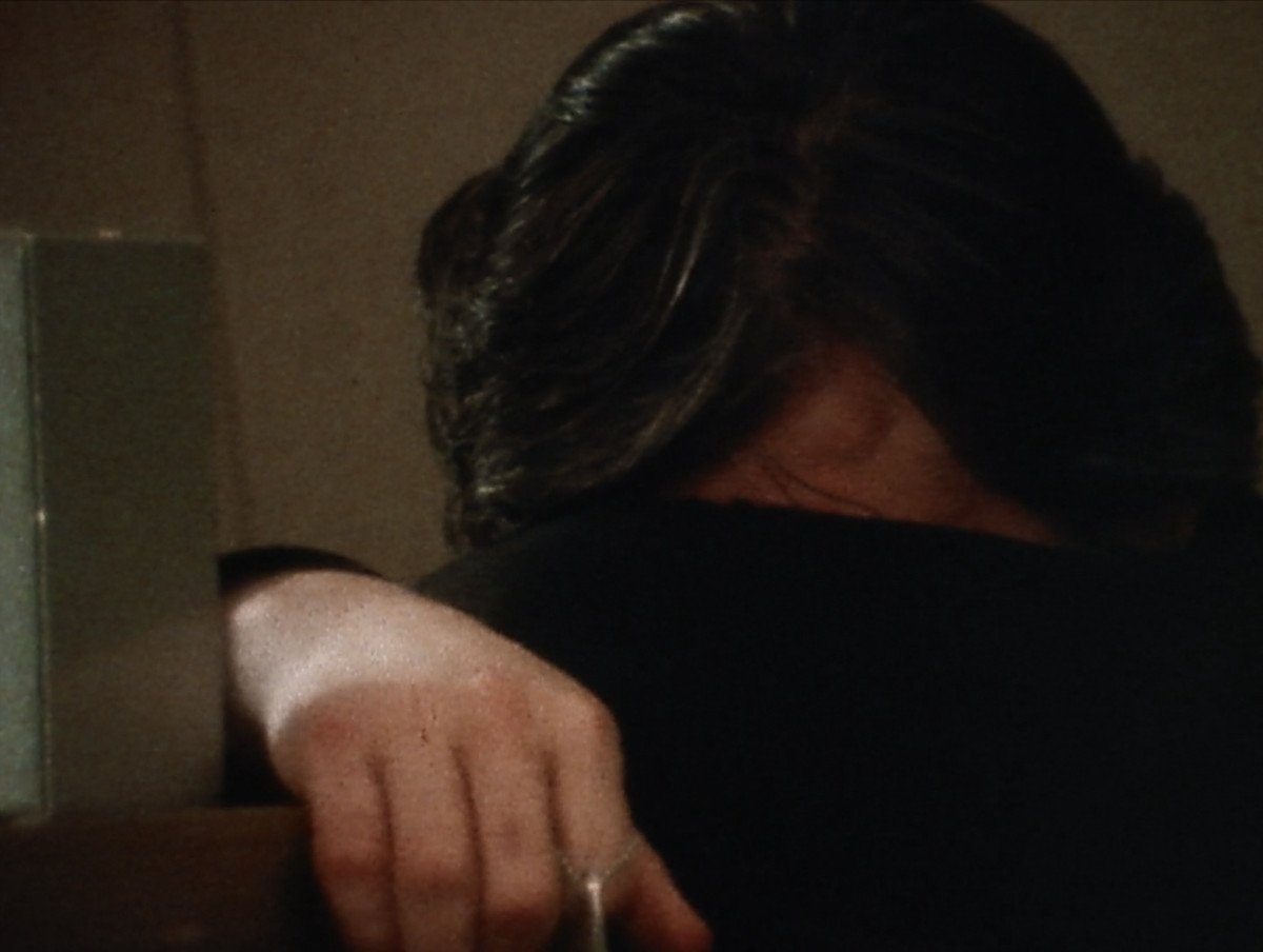 a man with dark hair buries his face