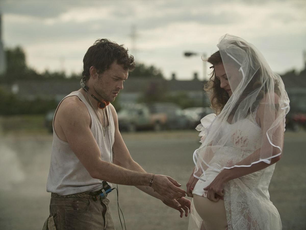 Alden Ehrenreich as John the Savage helps Lara Peake as Madysun in Brave New World.