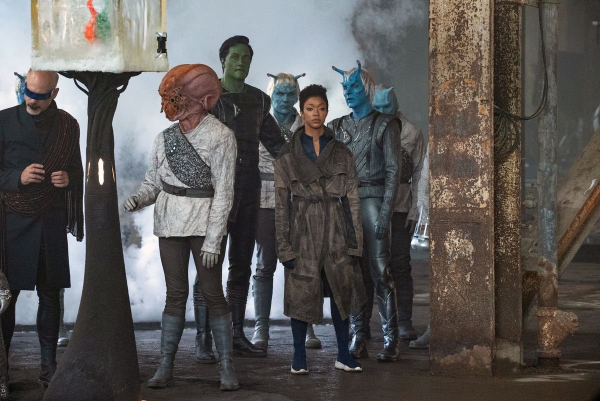 Sonequa Martin-Green as Michael Burnham stands in a group of aliens in Star Trek: Discovery