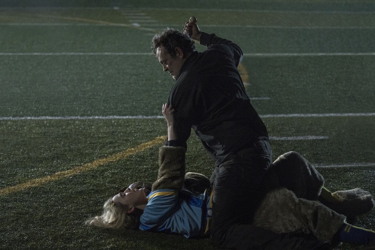 Vince Vaughn straddles Kathryn Newton at night on a football field as he attempts to stab her in Freaky