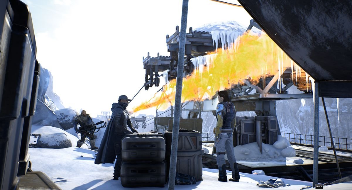 Three Outriders characters gather by some crates. One of them uses a flamethrower in the background