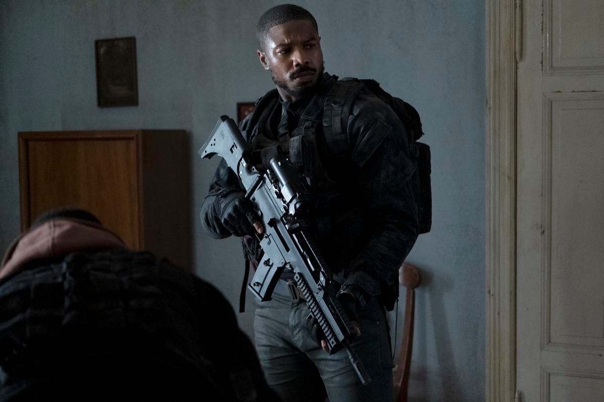 A glowering Michael B. Jordan hefts a very large assault rifle in Tom Clancy’s Without Remorse