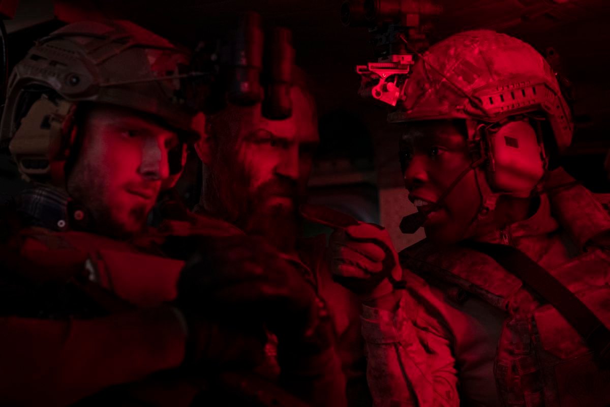 Jamie Bell, Jack Kesy, and Jodie Turner-Smith huddle in dim red light as Navy SEALs in Without Remorse
