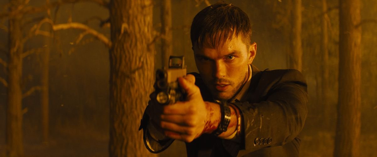 An agitated, bloodied Nicholas Hoult points a gun offscreen in Those Who Wish Me Dead