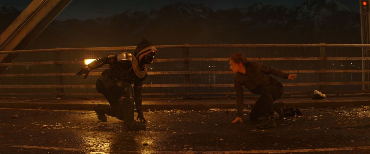 Black Widow faces off with the Taskmaster on a dark bridge in Marvel Studios’ Black WIdow