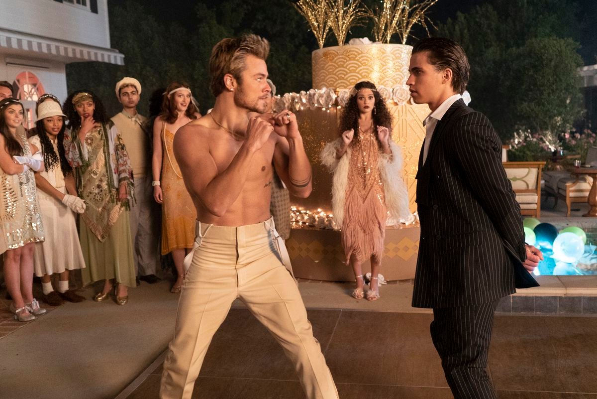a shirtless teenage boy about to fight a boy in a suit