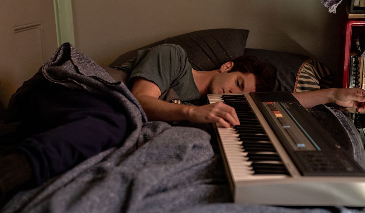 Andrew Garfield flops down by his keyboard in Netflix’s Jonathan Larson musical Tick, Tick… Boom!