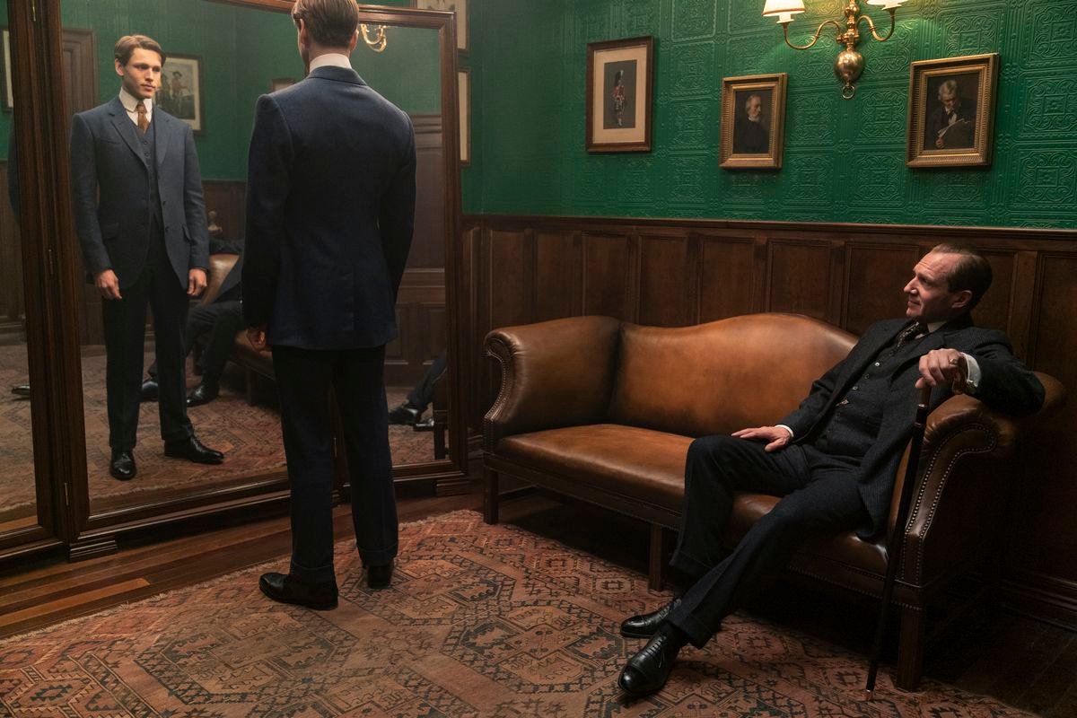 Orlando Oxford (Ralph Fiennes) sits as Conrad (Harris Dickinson) tries on his Kingsman suit