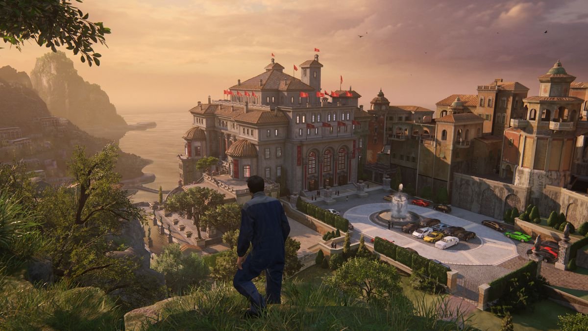 Nathan Drake stands on a ridge overlooking an opulent estate at sunset in Uncharted: Legacy of Thieves Collection’s remaster of Uncharted 4: A Thief’s End (screenshot captured in Performance mode)