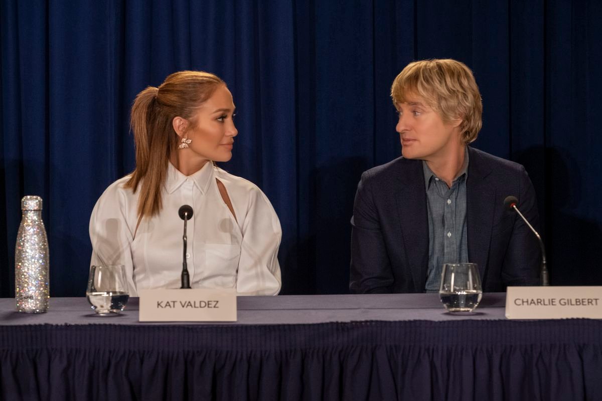 jennifer lopez and owen wilson sit at a press conference