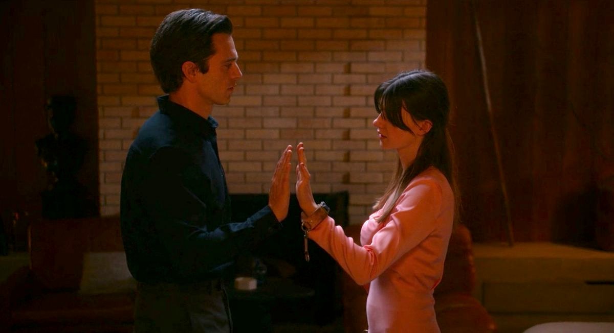 Sebastian Stan and Daisy Edgar-Jones stand facing each other with their palms pressed together in Fresh