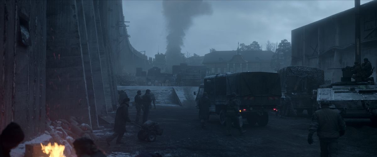 Military trucks gather at a bombed out base