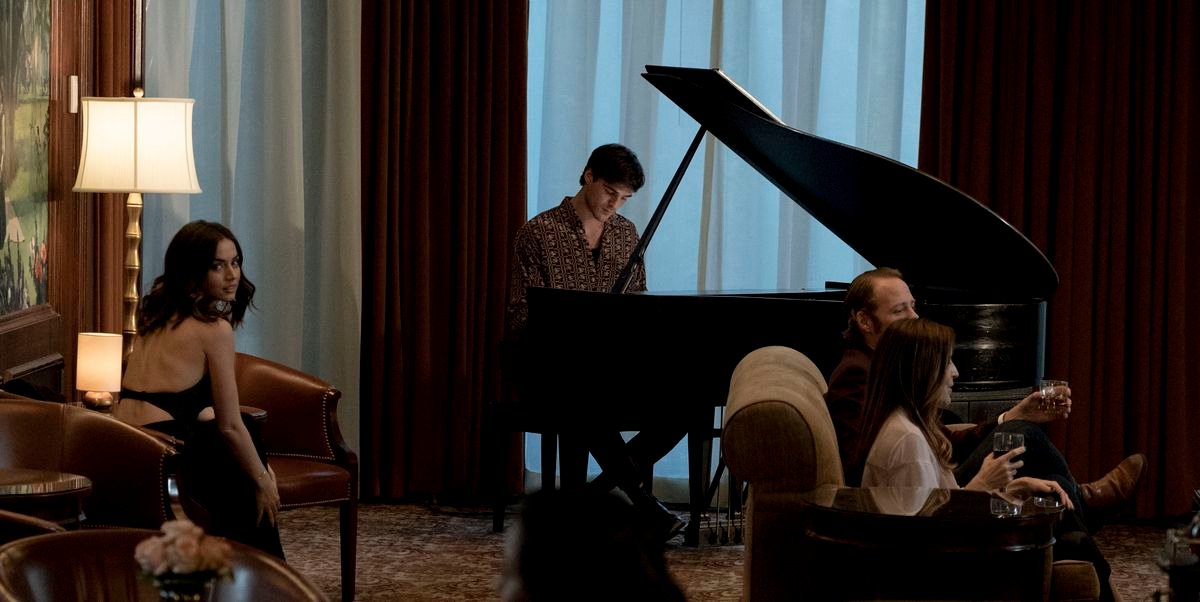 Ana de Armas sits near a cocktail pianist and looks over her shoulder