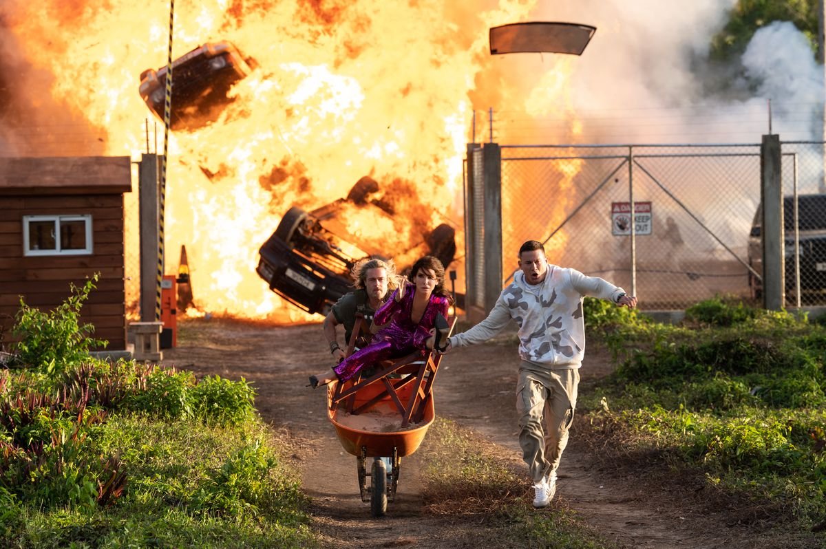 Channing Tatum and Brad Pitt wheel Sandra Bullock away from a huge explosion in a wheelbarrow in The Lost City