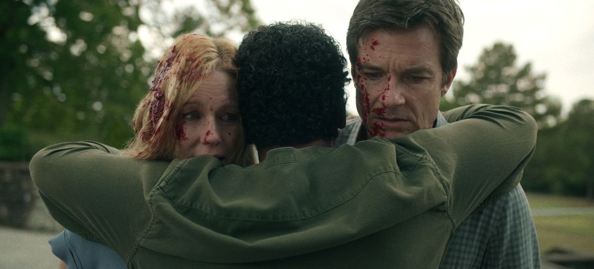 The Byrdes being hugged by a woman while their faces are covered in blood