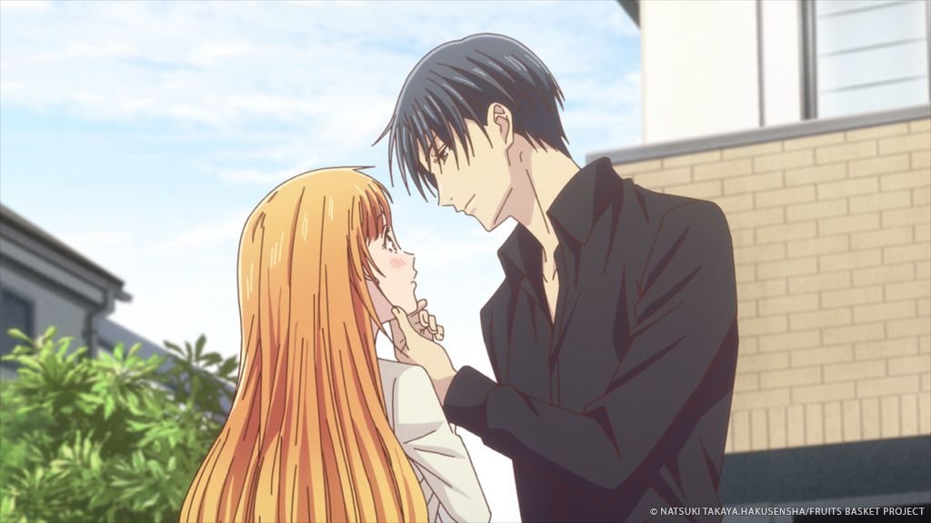 katsuya leaning down to cup kyoko’s face; he has dark hair and dark clothes, she has long orange hair