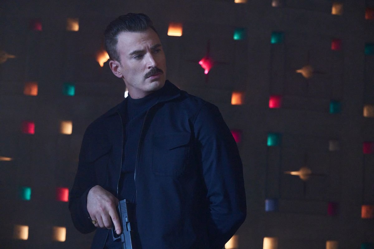 Chris Evans stands with a handgun pointed downward in Netflix’s The Gray Man