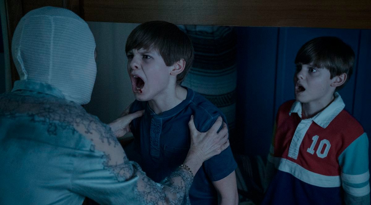 Mother (Naomi Watts) holds onto one of her twins as he screams in her face, as the other watches in shock, in the 2022 Goodnight Mommy
