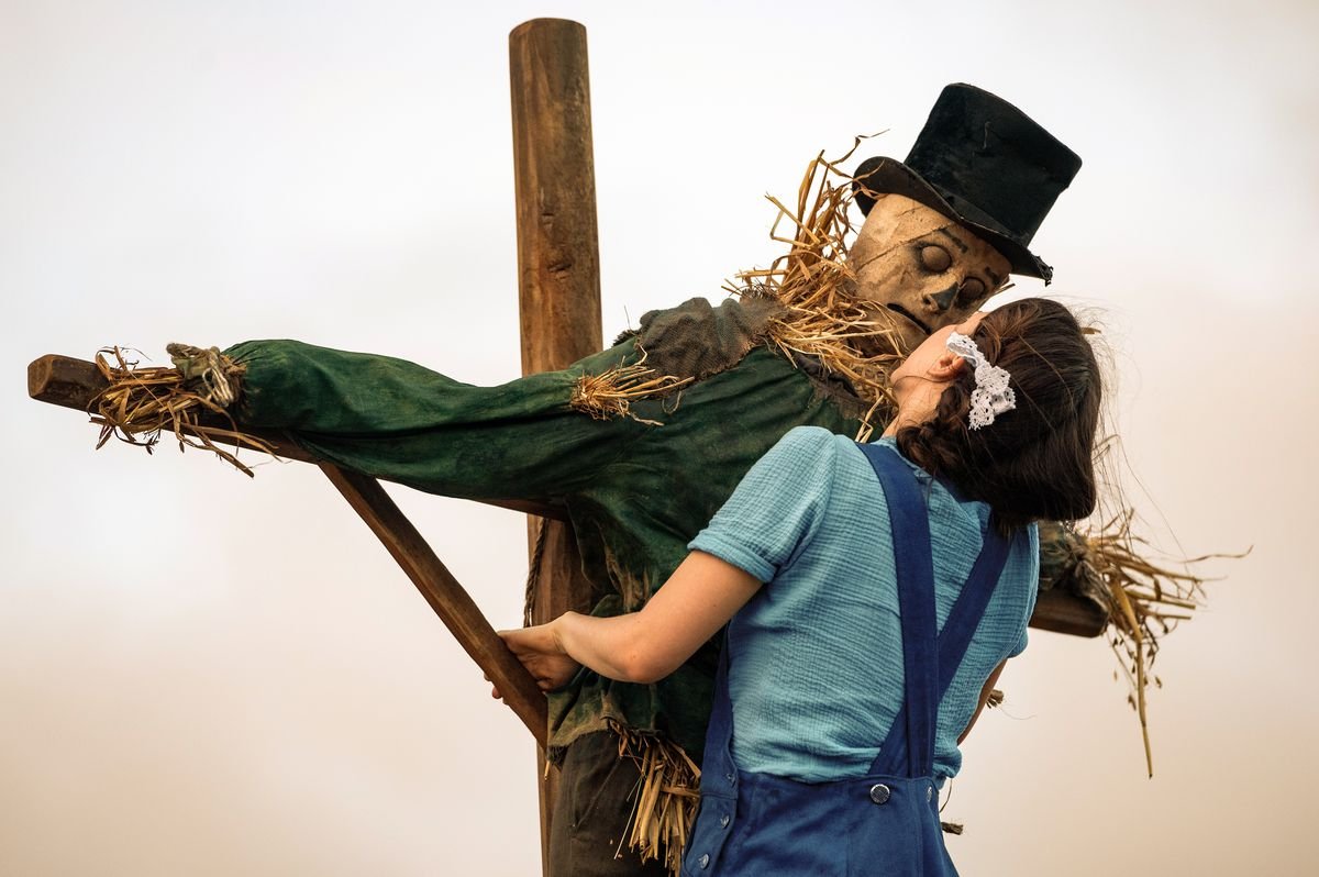 Mia Goth climbs up onto the perch of a creepy-looking scarecrow to give it a kiss in Ti West’s Pearl