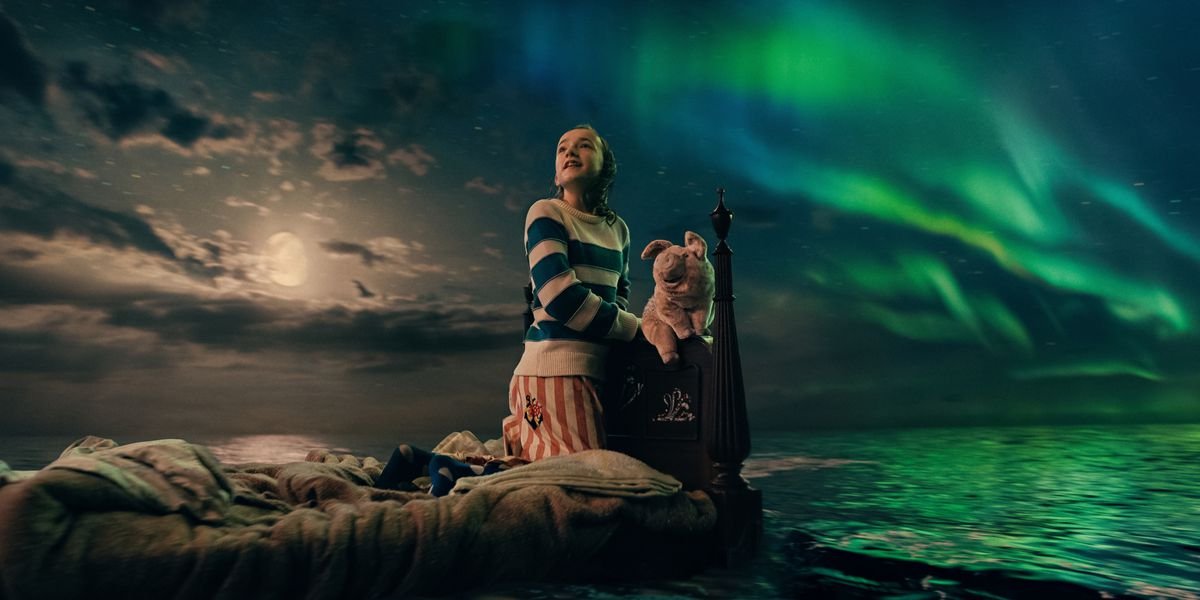 Marlow Barkley as Nemo in Slumberland, sitting on her bed, hair wet, with her animated stuffed pig. The bed floats on a calm ocean, lit by the nearly full moon and the aurora borealis.
