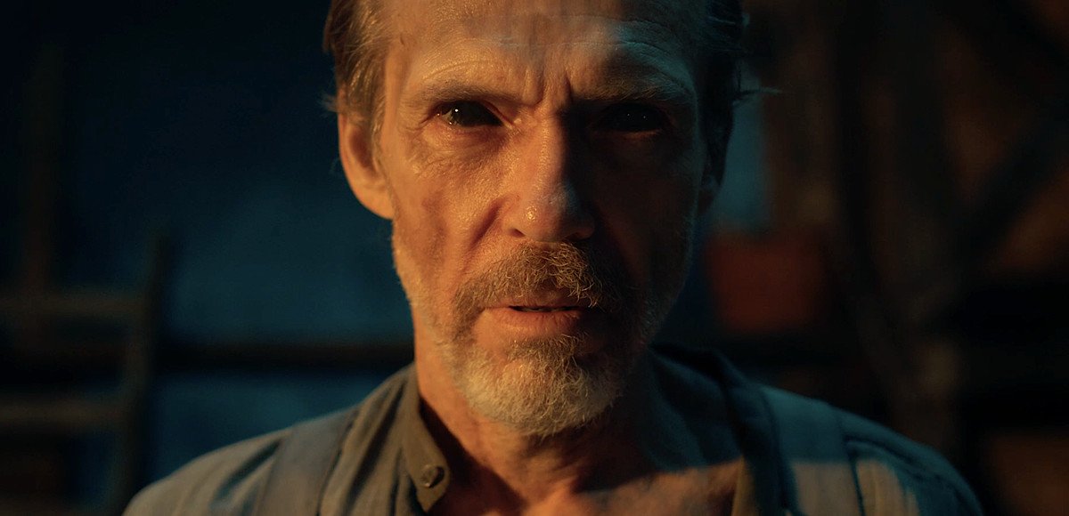 A gaunt, harried-looking Old West prospector stares into the camera with entirely black eyes after being possessed in RIPD 2: Rise of the Damned