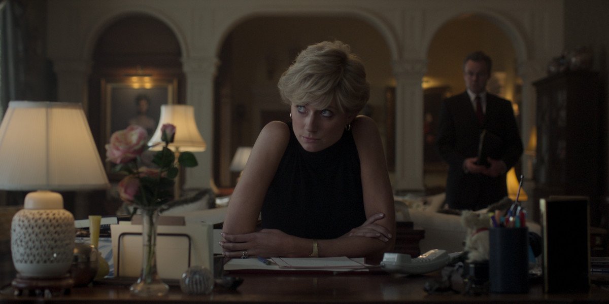 Elizabeth Debicki as Princess Diana, sitting at a desk and looking up at someone, in The Crown