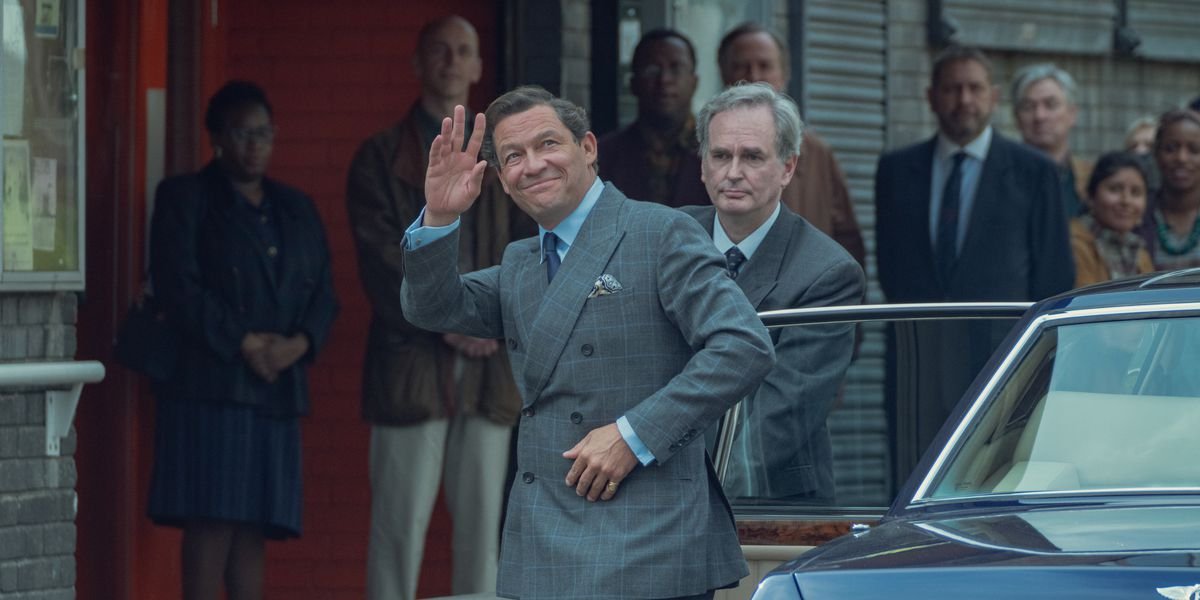 Dominic West as Prince Charles waving to the crowd in The Crown