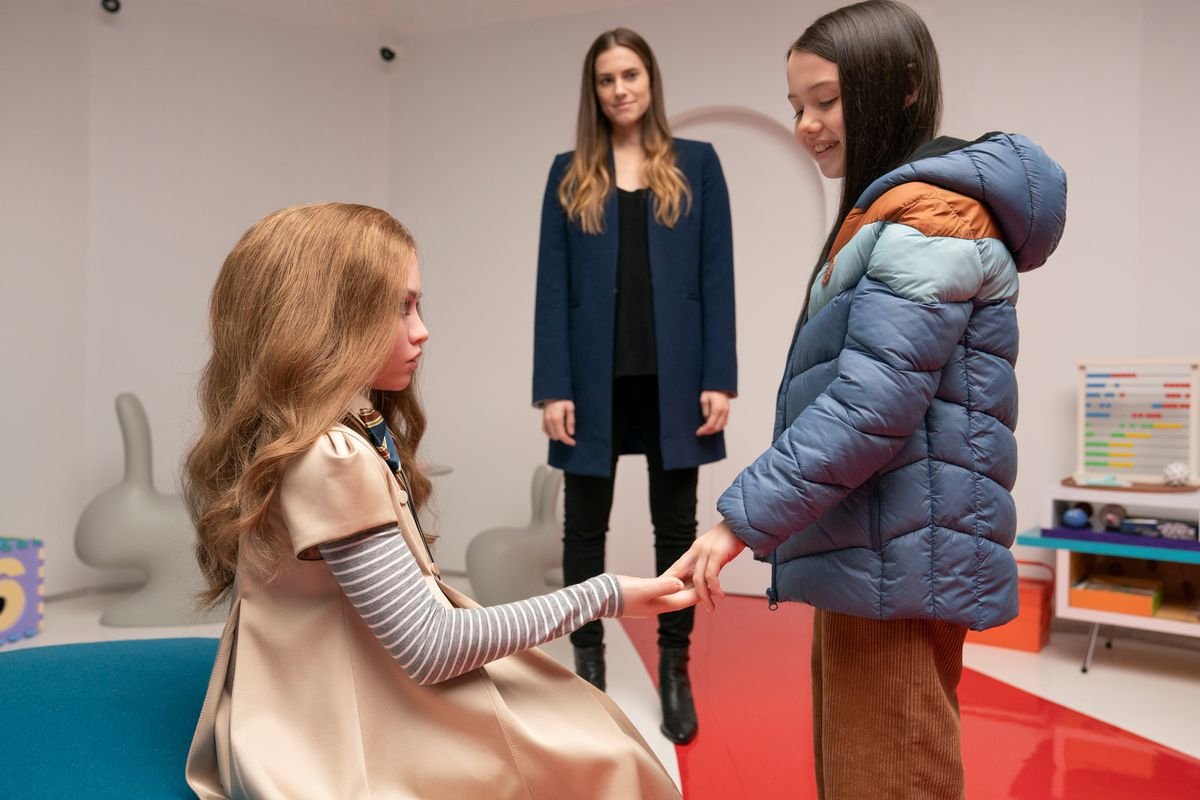 Gemma (Allison Williams) standing in the background with Megan the doll and Cady (Violet McGraw)