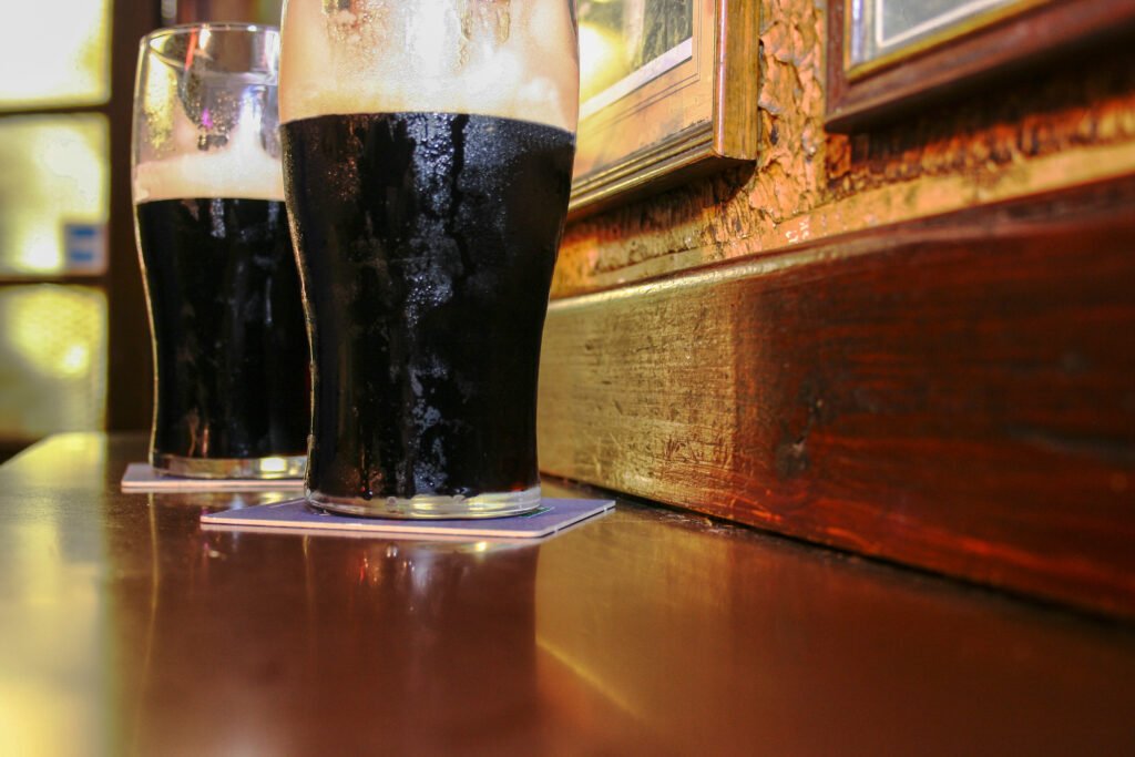 Δύο ποτήρια ιρλανδικής δυνατής μπύρας σε μια ξύλινη μπάρα