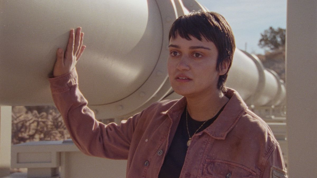 Xochi (Ariela Barer) runs her hand along an oil pipeline in How to Blow Up a Pipeline