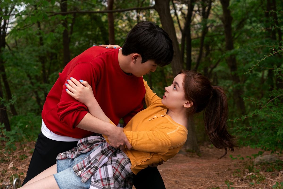 Dae, a Korean teenage boy, catches Kitty, a dark-haired half-Asian teenage girl, as she trips on a hiking trip. 