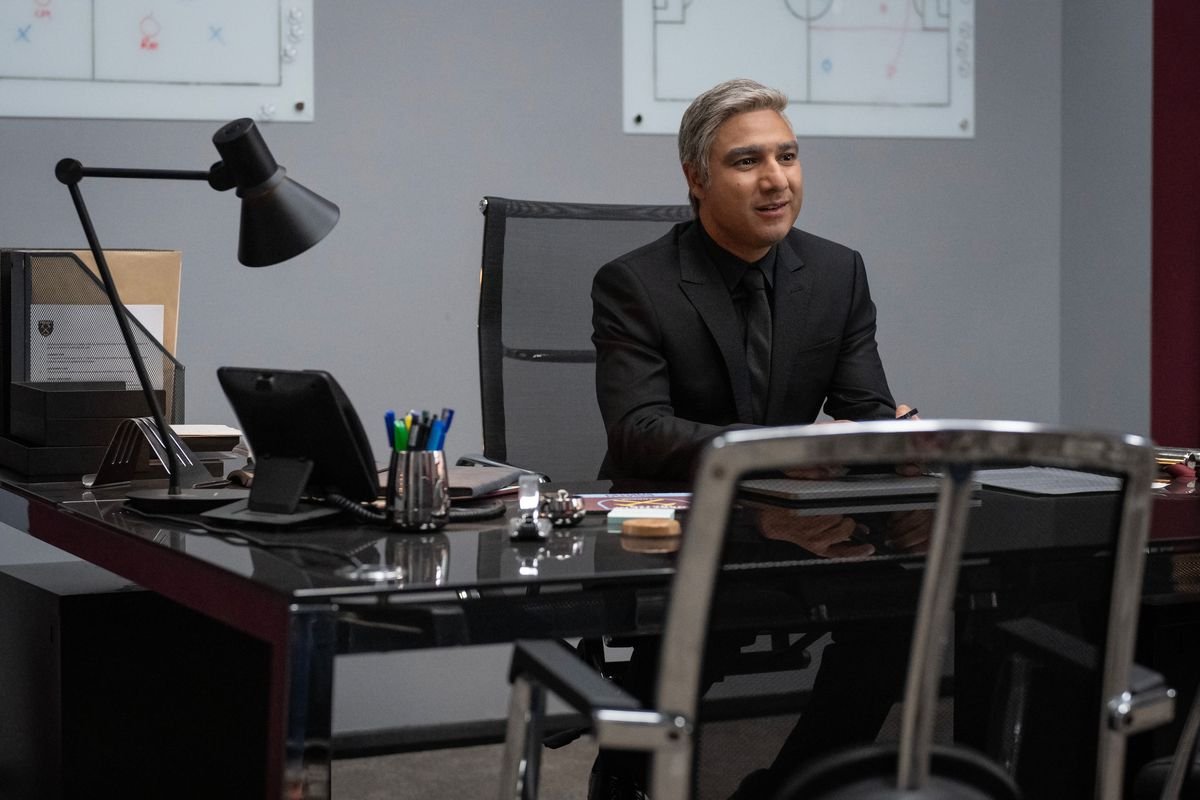 Nate (Nick Mohammed) sits at a desk in his West Ham office
