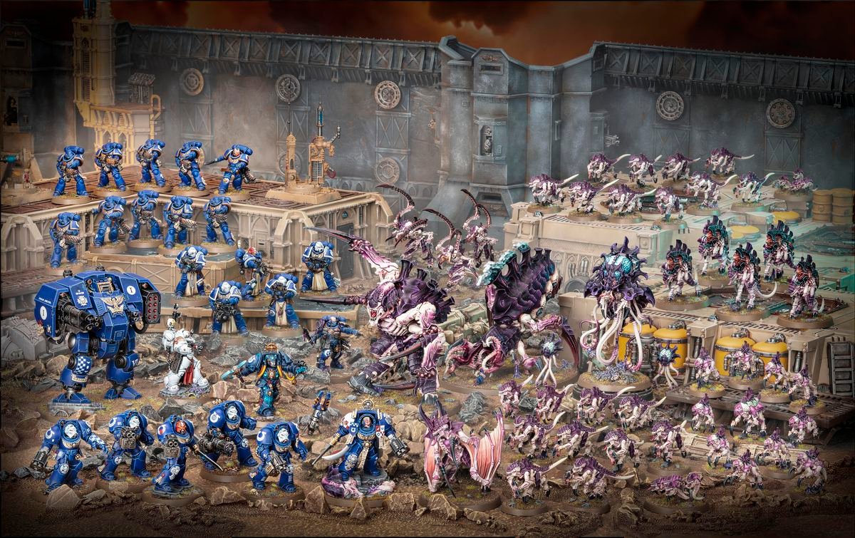 The complete Warhammer 40,000: Leviathan boxed set includes 72 miniatures, displayed here on plastic terrain that does not come with the set. Space Marines are blue, and Tyrannids are purple and pink. The scene is set along a large battlement.