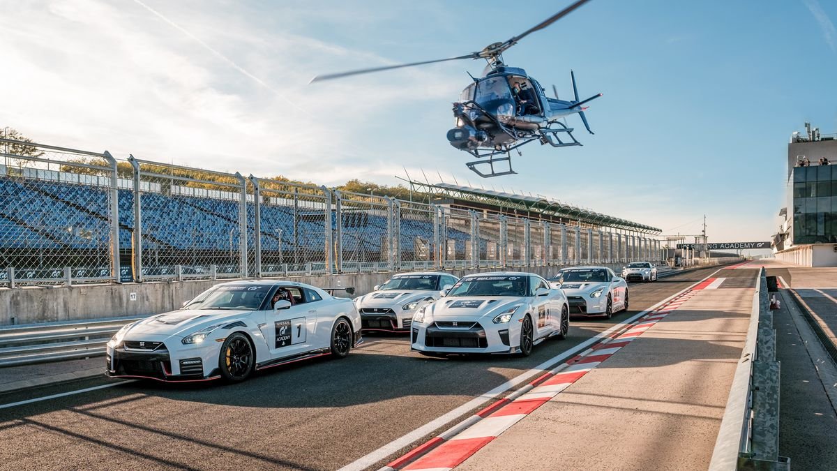 A helicopter buzzes a row of white Nissan racing cars in the Gran Turismo movie