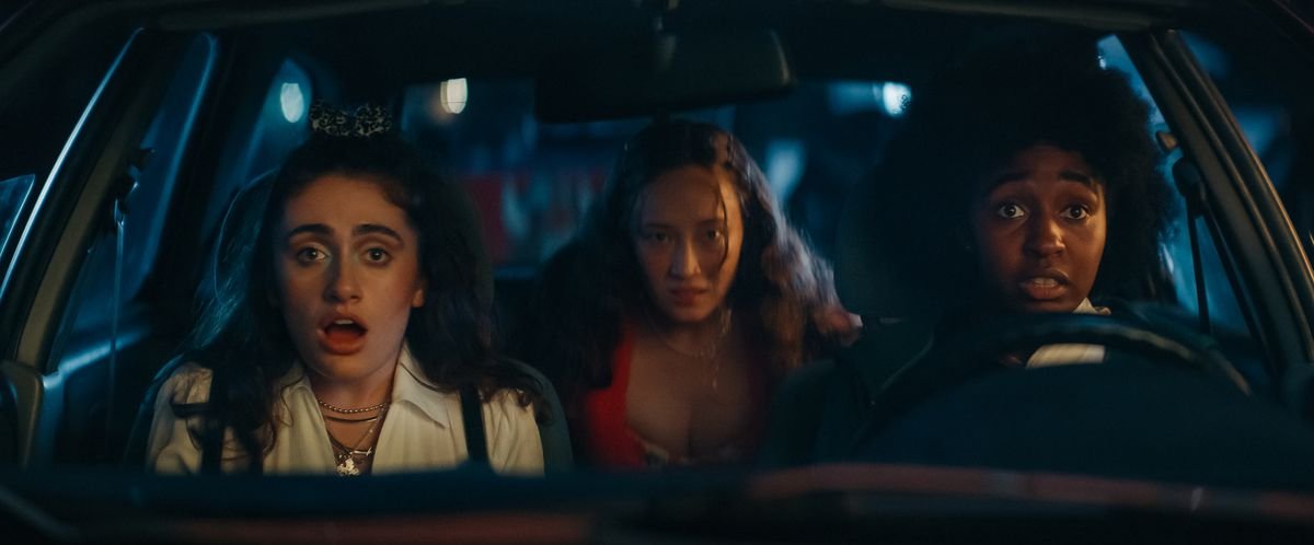 Josie and PJ driving a car, with Isabel in the backseat