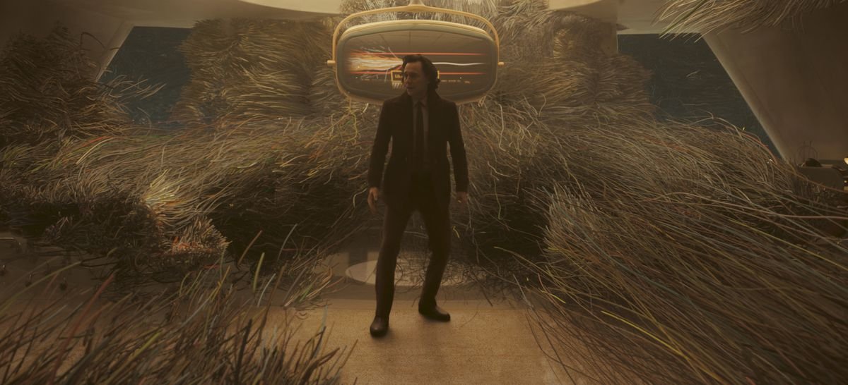 Loki (Tom Hiddleston) standing in the middle of the world turning to strands of spaghetti
