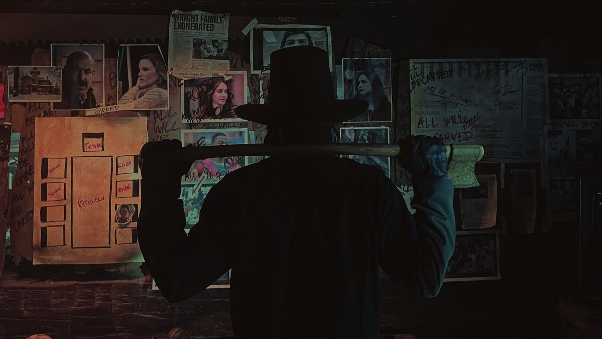 A man in a hat holding an axe faces a wall covered in photos from the movie Thanksgiving