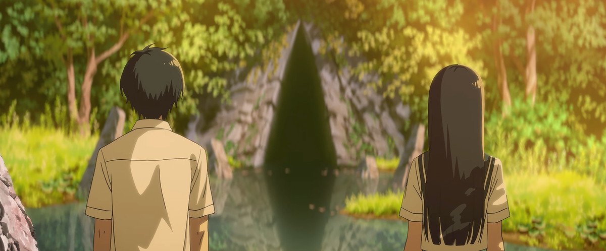 Two teenagers stare at the entrance to a tunnel, covered in foliage
