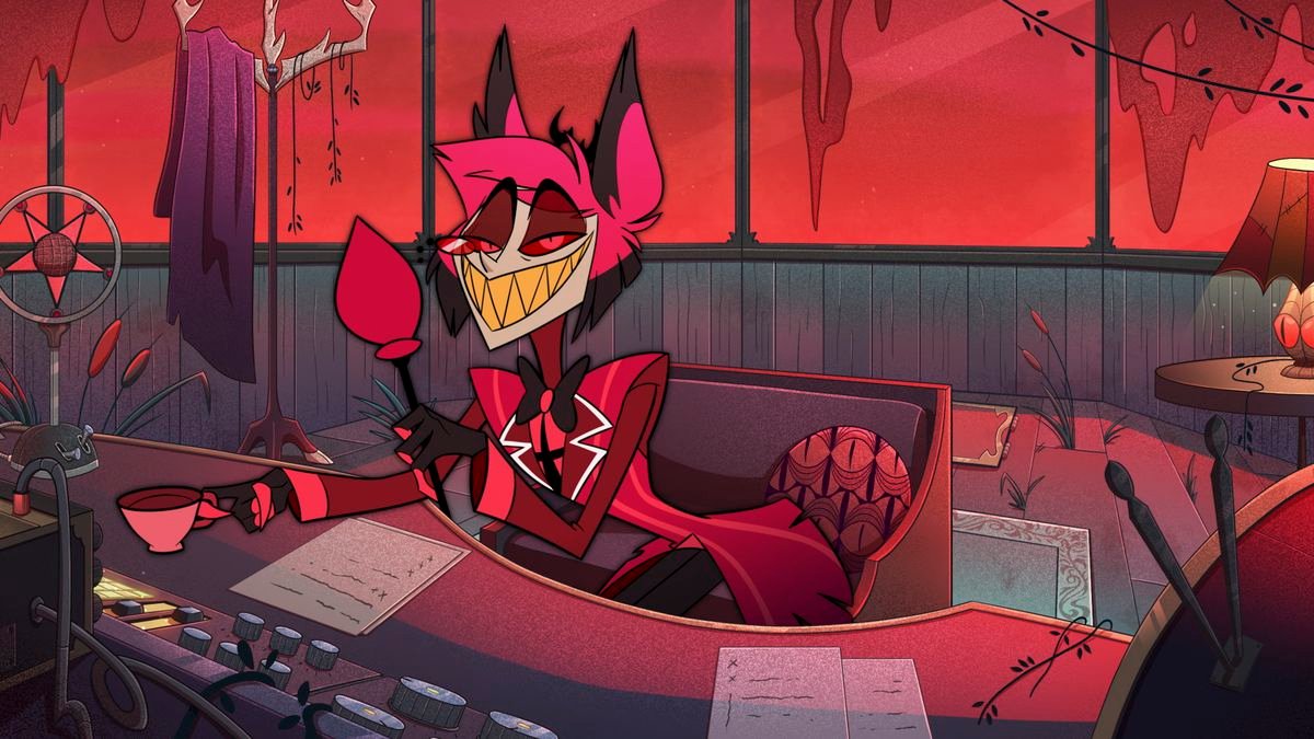A slim grey-skinned demon in a red suit, smiling through sharp, pointed yellow teeth, leans over a radio console.