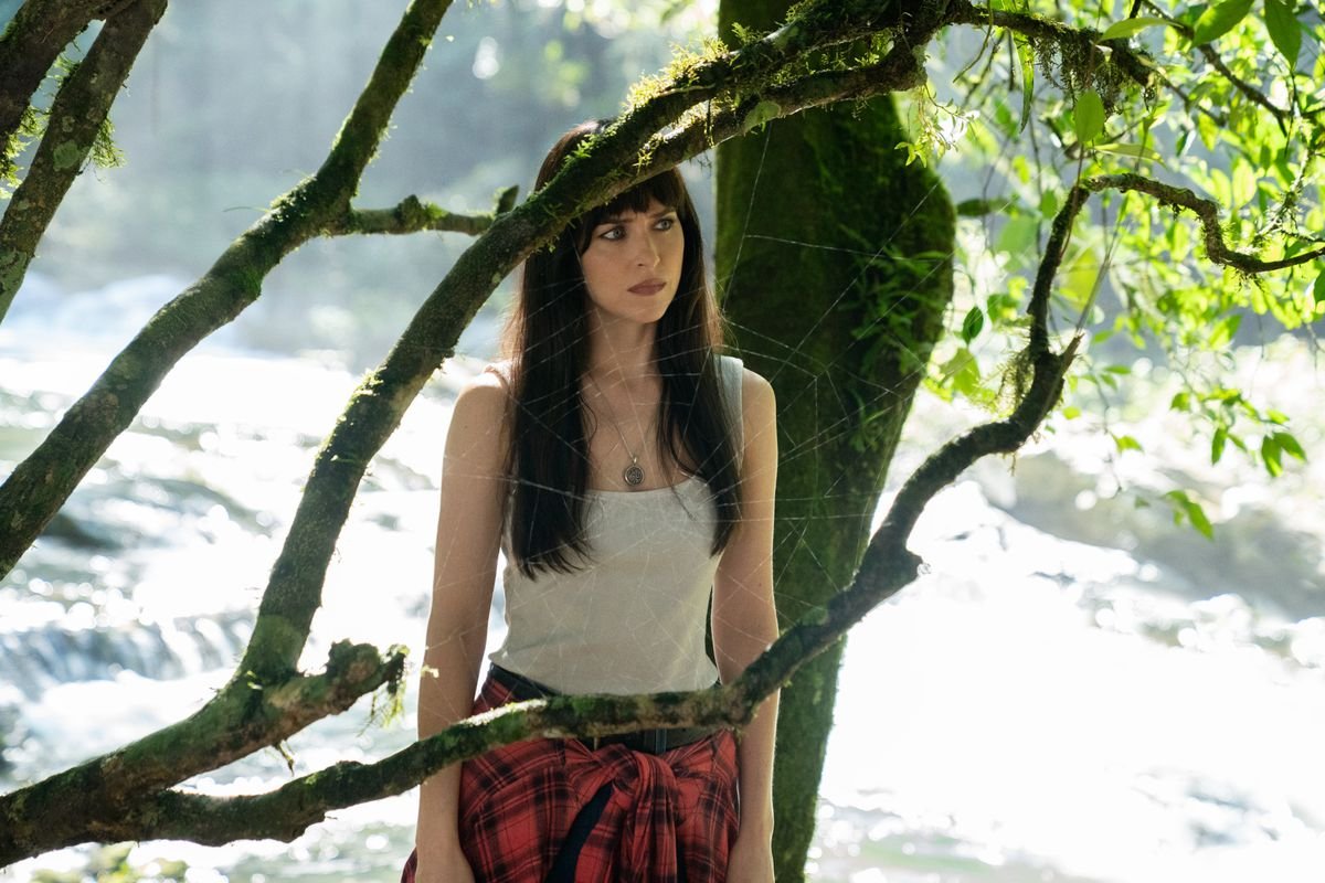 Dakota Johnson stands in front of a spider web in Madame Web