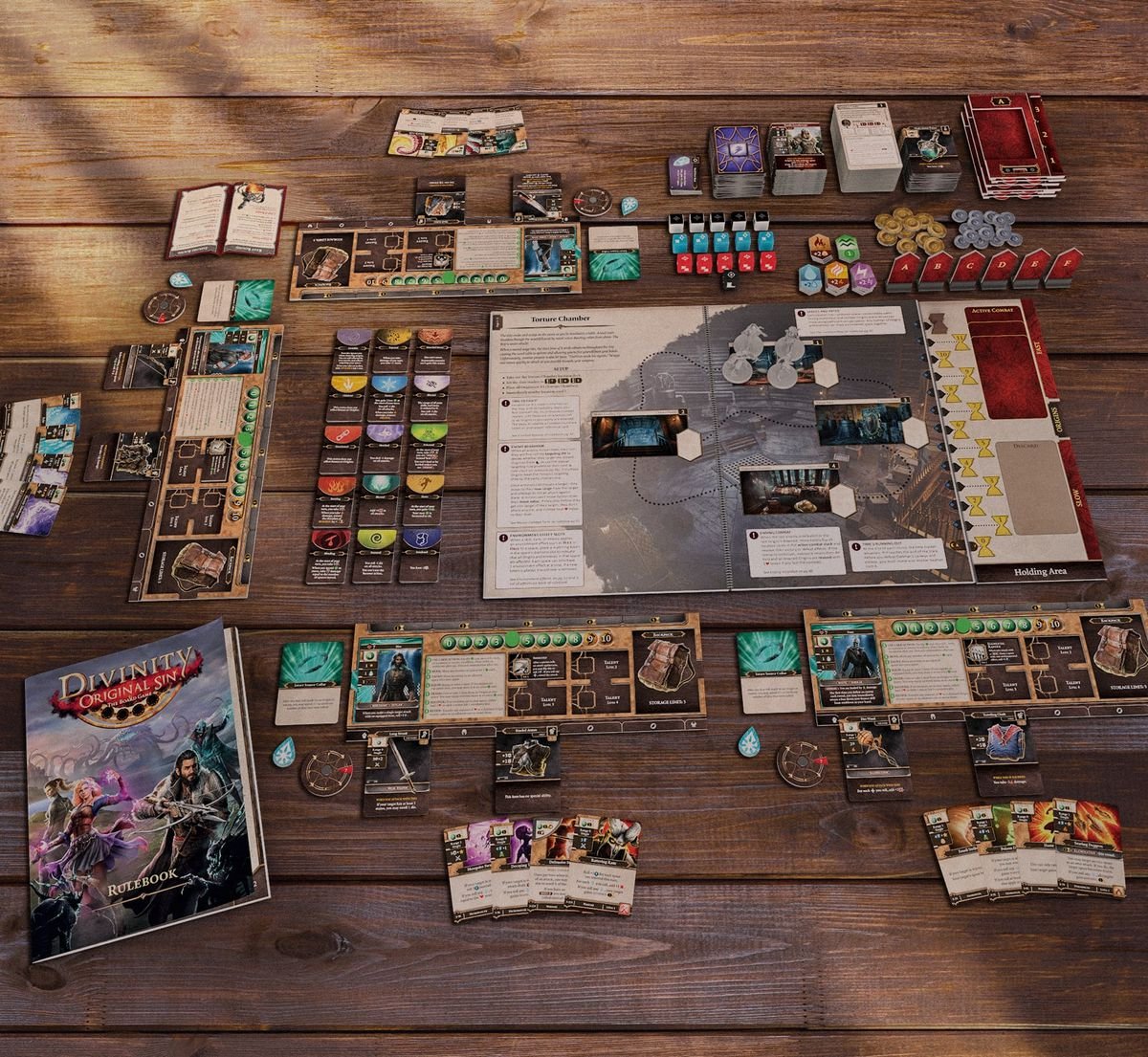 A product shot of the Divinity: Original Sin board game neatly arranged on a wooden table