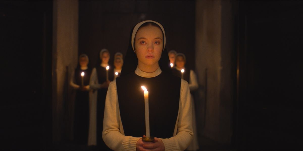 Sydney Sweeney in Immaculate holding a candle with nuns behind her