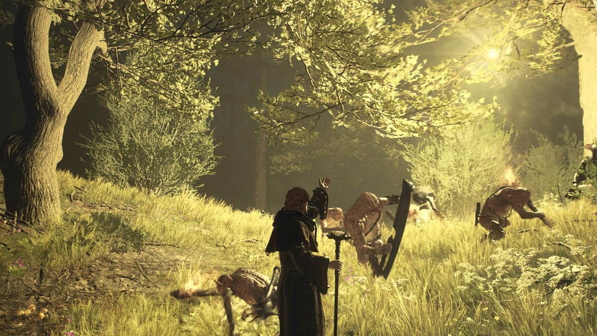 A mage casts an illumination spell in a forest at nighttime as goblins attack in a screenshot from Dragon’s Dogma 2