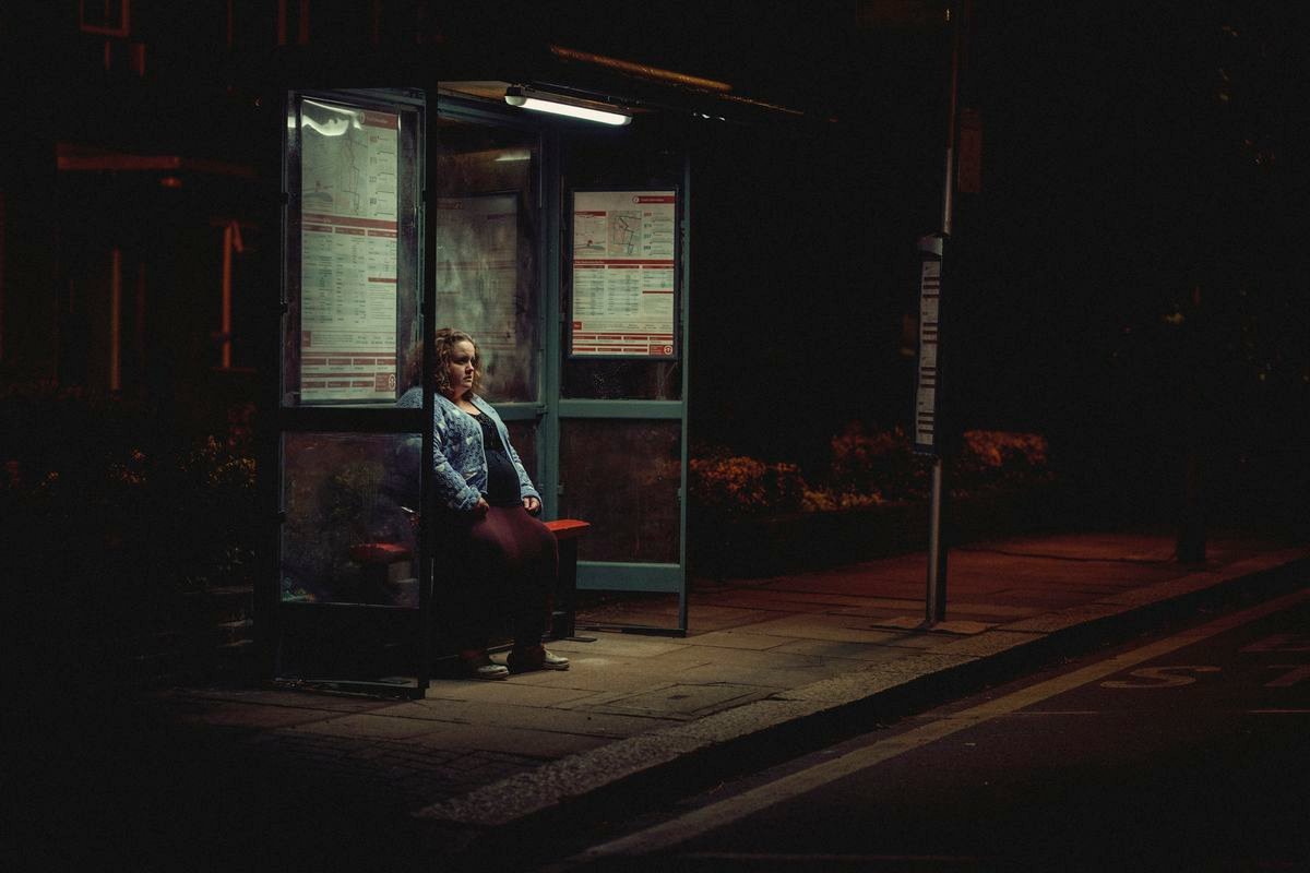 Jessica Gunning sits alone at a bus stop at night in Baby Reindeer